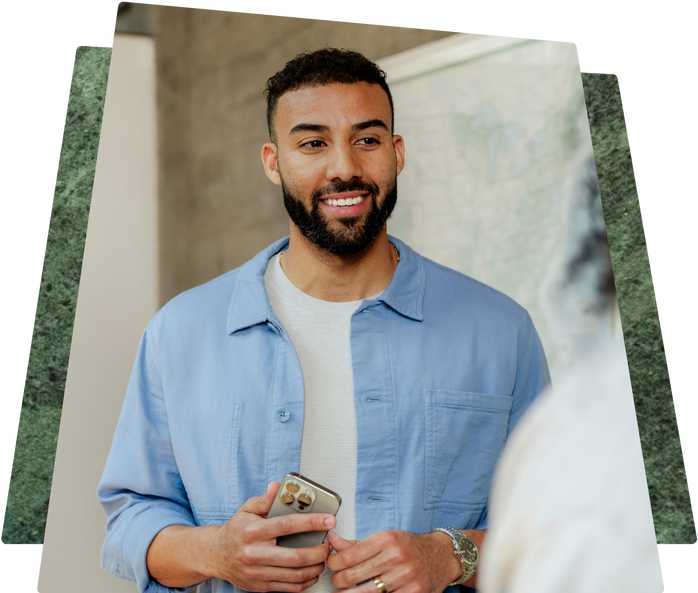 A Shopify merchant smiling while holding a smartphone, with overlay text displaying financial information: "Daily sales: $6,000," "Capital repayment: $600," and "Daily balance: $5,400."